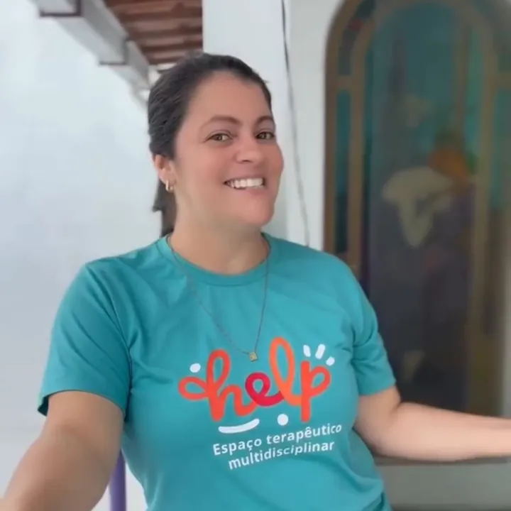 Profissional da Help! sorrindo, com a camiseta da clínica